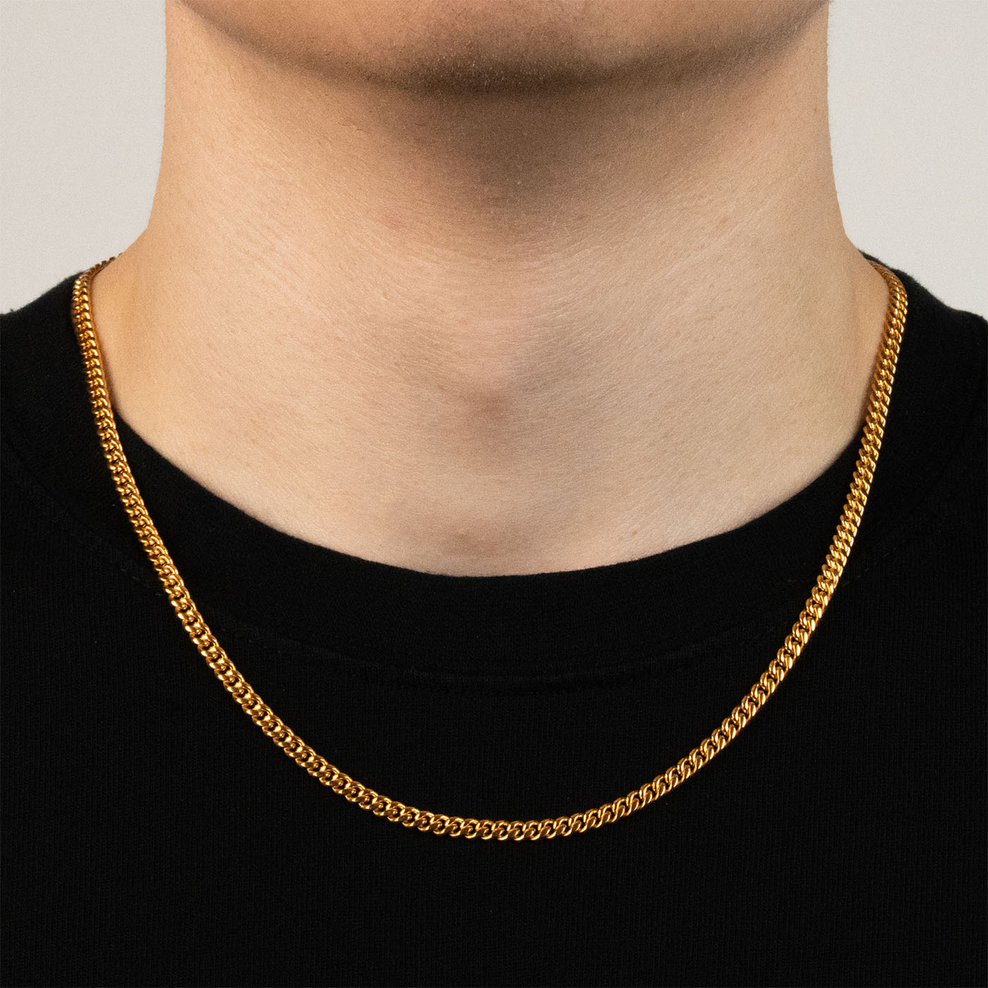 Model trägt eine goldfarbene Cuban-Halskette aus 316L Edelstahl mit einem Gewicht von 16,7 g.