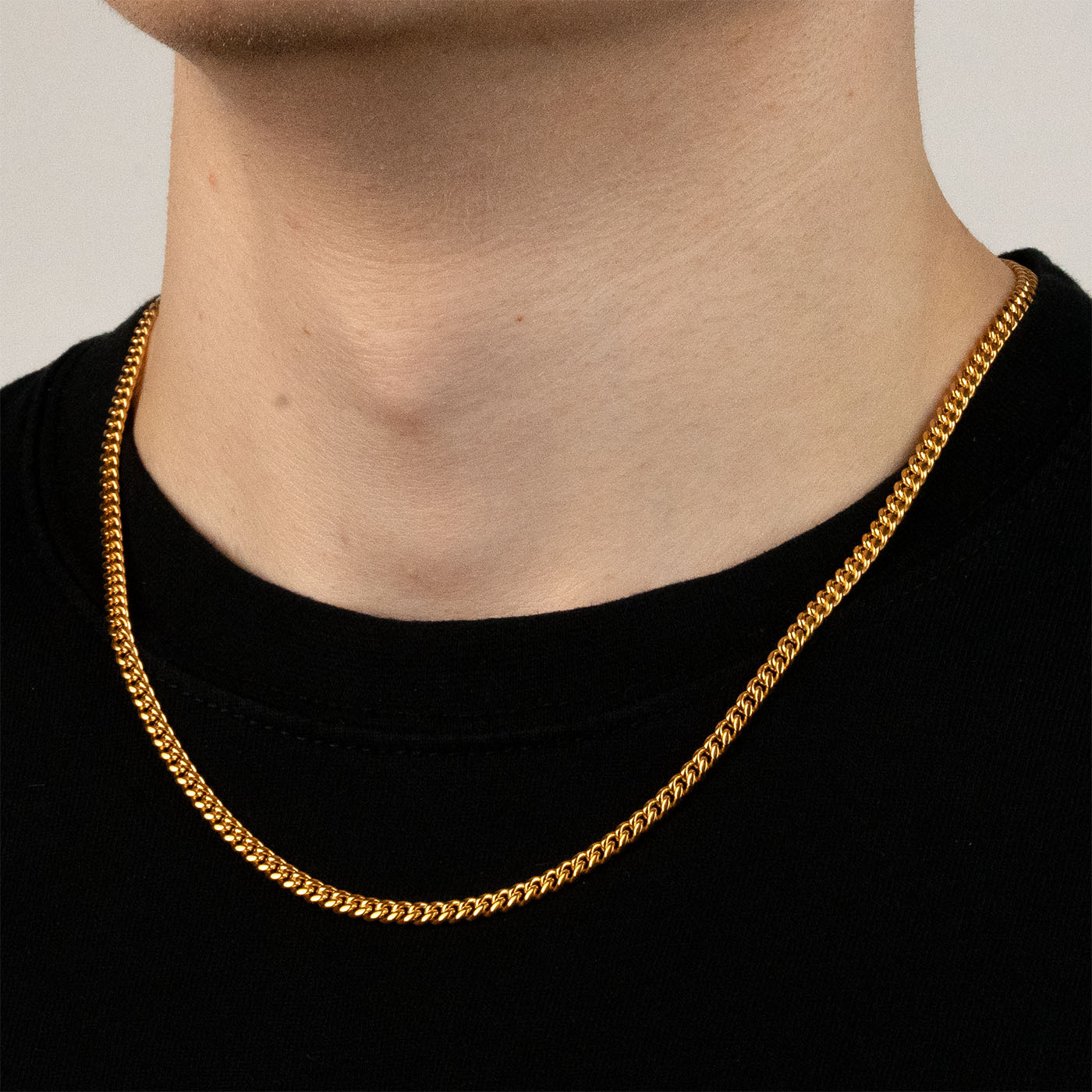 Model trägt eine goldfarbene Cuban-Halskette aus 316L Edelstahl mit einem Gewicht von 16,7 g.