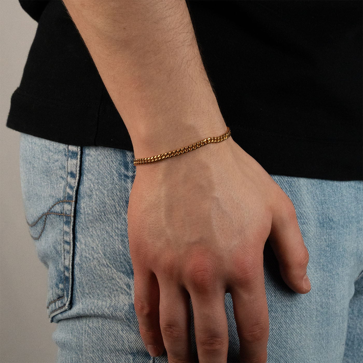 Model trägt ein goldfarbenes Cuban-Armband aus 316L Edelstahl mit einem Gewicht von 6,3 g.