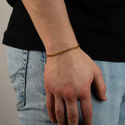 Model trägt ein goldfarbenes Cuban-Armband aus 316L Edelstahl mit einem Gewicht von 6,3 g.