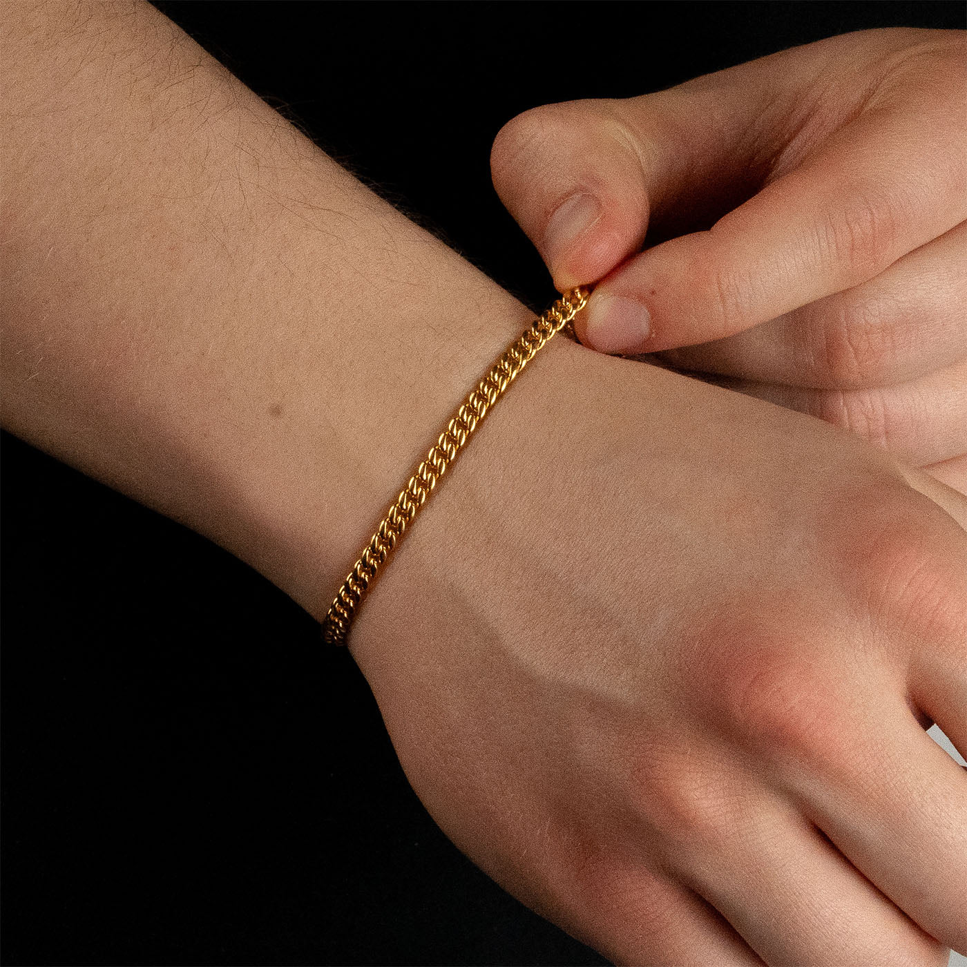 Model trägt ein goldfarbenes Cuban-Armband aus 316L Edelstahl mit einem Gewicht von 6,3 g.