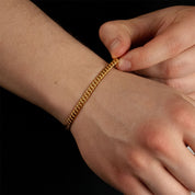 Model trägt ein goldfarbenes Cuban-Armband aus 316L Edelstahl mit einem Gewicht von 6,3 g.