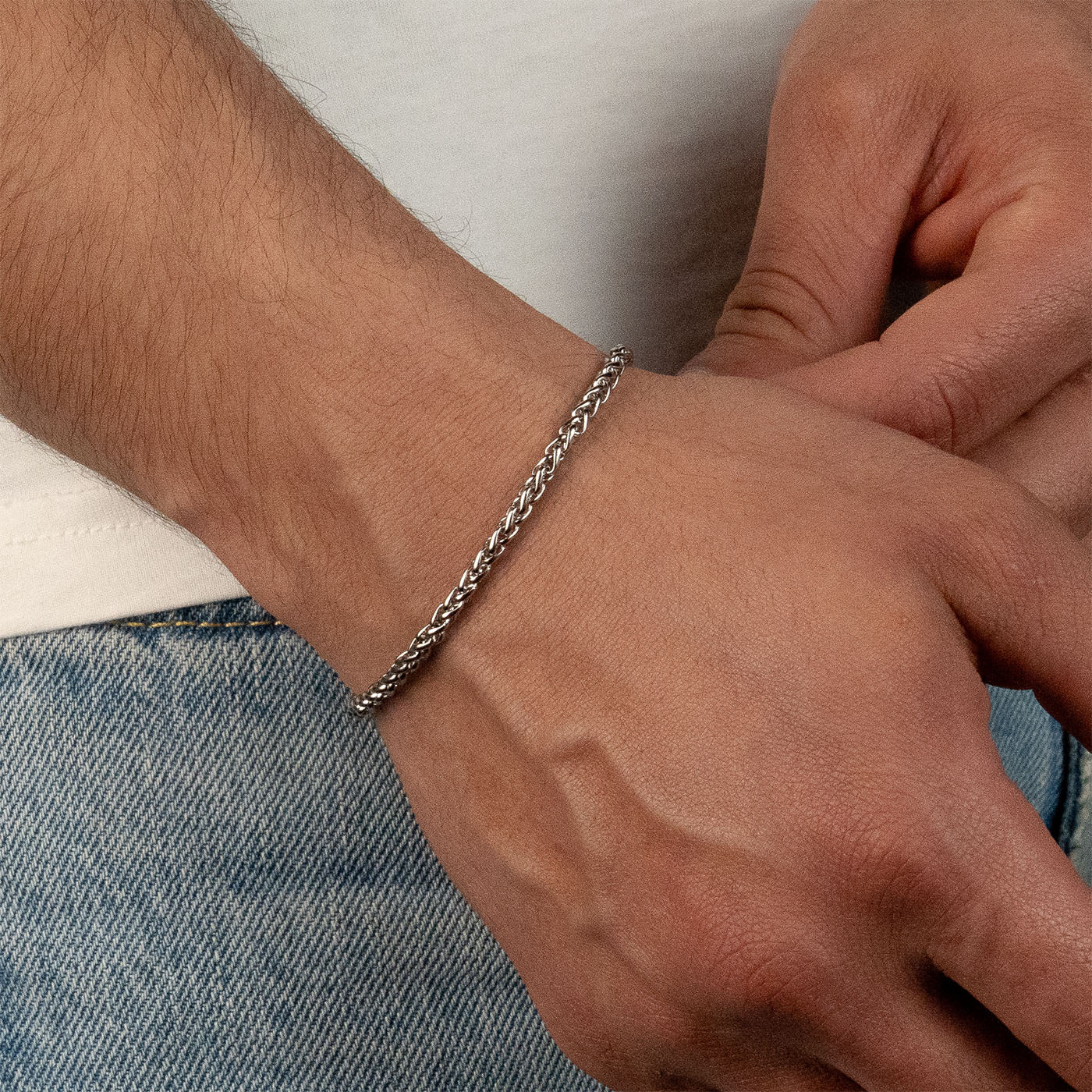 Model trägt ein silberfarbenes Wheat-Armband aus 316L Edelstahl mit einem Gewicht von 5,1 g.