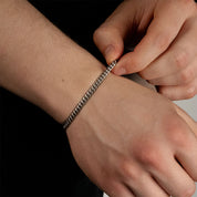 Model trägt ein silberfarbenes Cuban-Armband aus 316L Edelstahl mit einem Gewicht von 6,3 g.