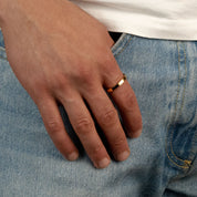 Model trägt einen goldfarbenen Band-Ring aus 316L Edelstahl mit einem Gewicht von 2,6 g.