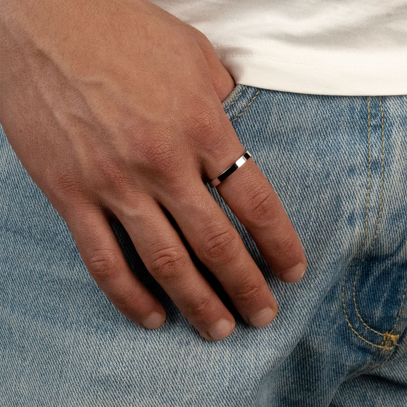 Model trägt einen silberfarbenen Band-Ring aus 316L Edelstahl mit einem Gewicht von 2,6 g.