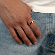 Model trägt einen silberfarbenen Band-Ring aus 316L Edelstahl mit einem Gewicht von 2,6 g.