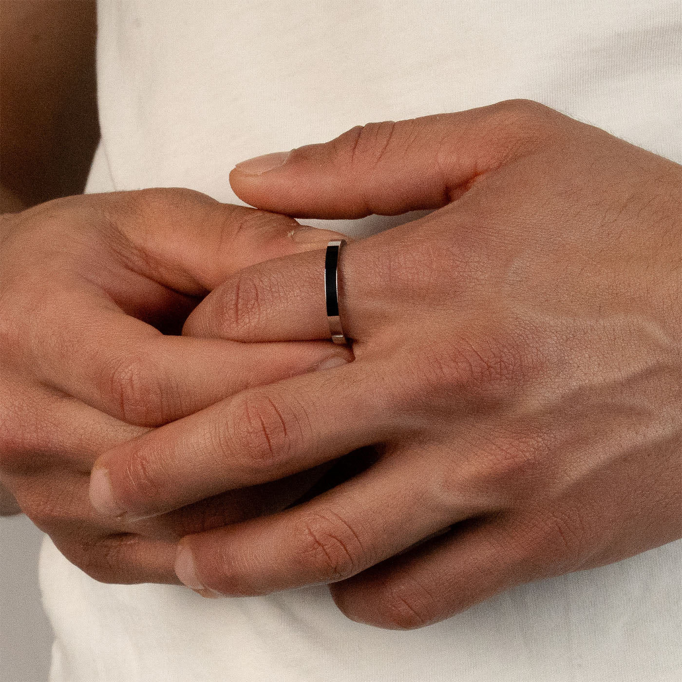 Model trägt einen silberfarbenen Band-Ring aus 316L Edelstahl mit einem Gewicht von 2,6 g.