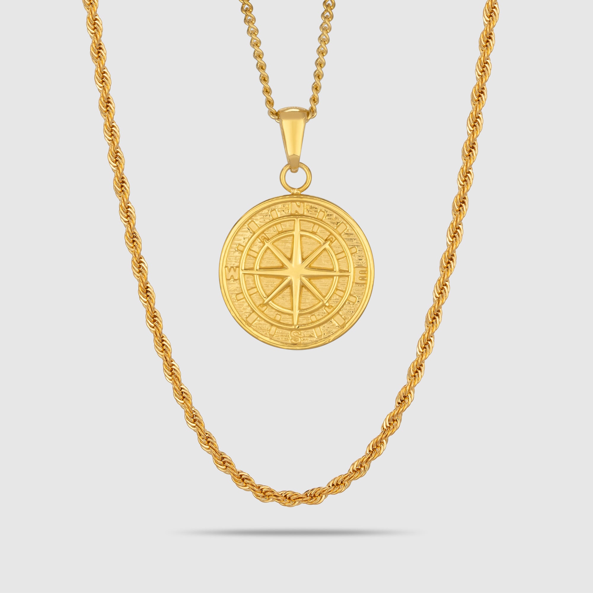 Model trägt ein goldfarbenes Schmuckset aus einer Rope-Halskette und einem Kompass-Anhänger aus 316L Edelstahl mit einem Gesamtgewicht von 15,4 g.