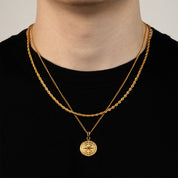 Model trägt ein goldfarbenes Schmuckset aus einer Rope-Halskette und einem Kompass-Anhänger aus 316L Edelstahl mit einem Gesamtgewicht von 15,4 g.