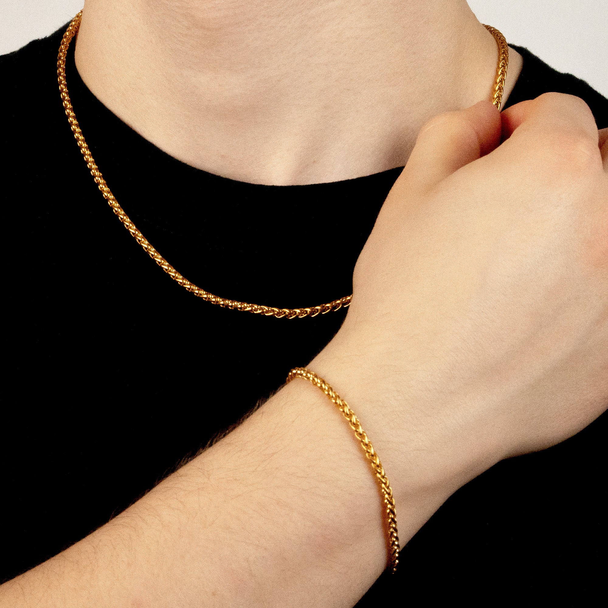 Model trägt ein goldfarbenes Schmuckset aus einer Wheat-Halskette und einem passenden Wheat-Armband aus 316L Edelstahl mit einem Gesamtgewicht von 18,6 g