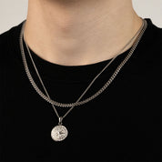 Model trägt ein silberfarbenes Schmuckset aus einer Cuban-Halskette und einem Kompass-Anhänger aus 316L Edelstahl mit einem Gesamtgewicht von 20,7 g.